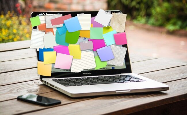 Laptop volgeplakt met post-its als beeld voor een druk schema